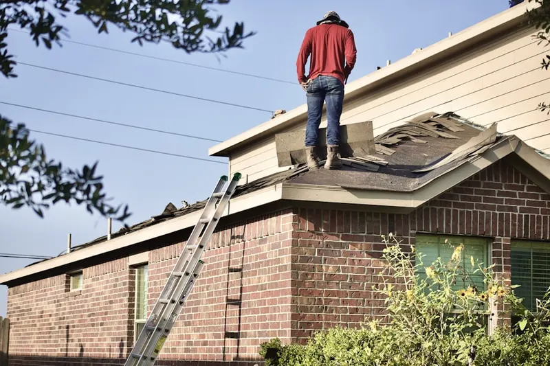 Professional roofer working on a residential roof in Fort Monmouth